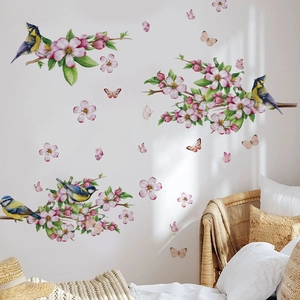 Floral wall decal with peach blossoms and blue tits in a bright cozy bedroom setting