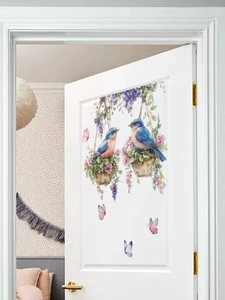 Dettaglio dell'adesivo murale con uccellini blu e cesti floreali in un ambiente domestico