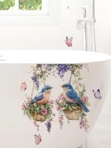 Dettaglio di adesivi con uccelli blu e fiori di glicine su una vasca da bagno bianca