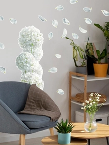 Close-up of white hydrangea wall decals with scattered petals in a cozy living room scene