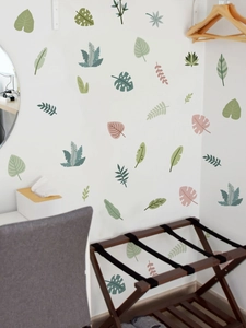 Macro view of tropical green leaf wall stickers in Morandi tones on a clean indoor wall