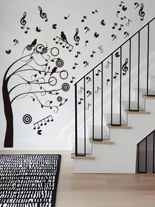 Détail de stickers muraux arbre musical avec oiseaux et papillons sur le mur d'escalier