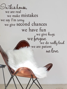 Detail of black vinyl wall decal with inspirational quotes near a leather chair