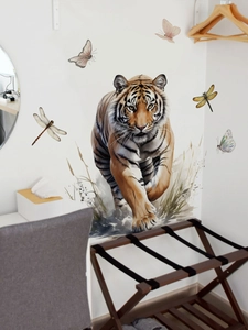 Detail of realistic tiger wall sticker set with butterflies and grass on a white wall
