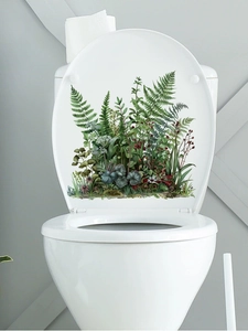 Détail d'autocollants de plantes vertes adhésifs appliqués sur un abattant de WC blanc