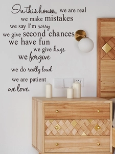 Detail view of black PVC wall decal with English motivational family quotes on white wall