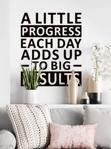 Close-up of motivational vinyl wall decal featuring black lettering on home living room wall