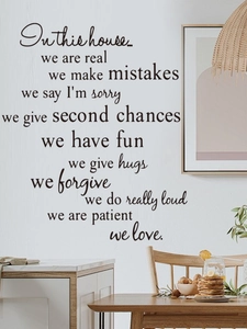 Detail of In This House family rules wall decal with elegant script typography on white wall