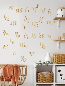 Dettaglio macro di adesivi murali alfabeto in PVC oro metallizzato per decorazioni casa