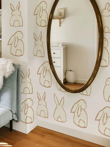 Detail of warm brown bunny wall stickers on a neutral wall in a cozy nursery room setting