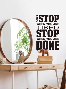 Dettaglio dell'adesivo murale nero con frase motivazionale in camera da letto moderna