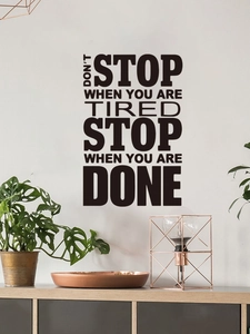 Dettaglio di adesivo murale nero in PVC con frase motivazionale nel soggiorno