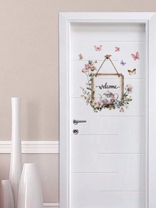 Detail of floral butterfly self-adhesive door sticker with welcome sign on white door