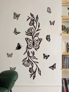 Detail of black PVC butterfly wall stickers with elegant floral vines on a living room wall
