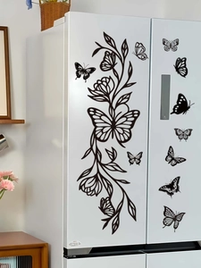 Detail of black butterfly and floral vine stickers on white refrigerator surface
