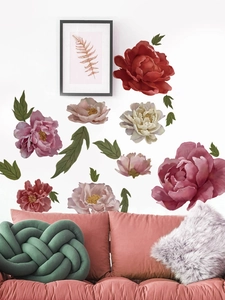 Detail von Pfingstrosen-Wandaufklebern an einer weißen Wand über einem rosa Sessel