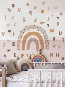 Detail of bohemian rainbow and alphabet wall decals in a cozy nursery room setting