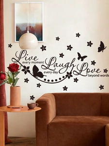 Detail of PVC wall sticker with black lettering and butterfly silhouettes on a warm background