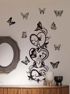 Detail of black butterfly and heart silhouette wall decal on a warm white living room wall