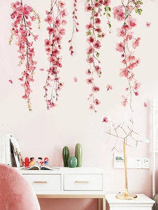 Detail of pink cherry blossom wall stickers with green leaves on a warm bedroom background