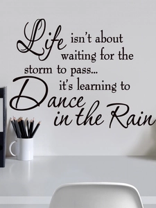 Detail of black vinyl wall decal with inspirational English quote on a white wall