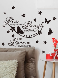 Detail of black vinyl wall decal with inspirational quotes and butterfly motifs in a cozy room