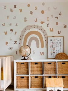 Detail of earthy rainbow wall decals with alphabet and number stickers in a cozy nursery