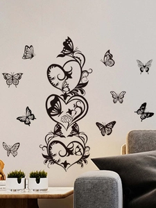 Detail of black butterfly and vine heart wall stickers on a minimalist living room wall