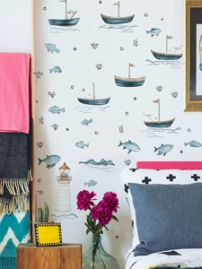 Detail of nautical wall decals with sailboats, lighthouse and waves in a bedroom setting