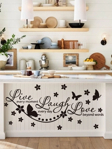 Detail of PVC wall sticker with 'Live Laugh Love' quote and butterfly on kitchen cabinet