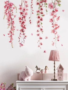 Floral wall decal featuring pink cherry blossom branches draped over a clean white wall