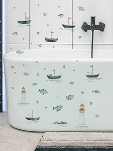Detail of nautical PVC wall stickers with sailboats and fish on bathroom tiles