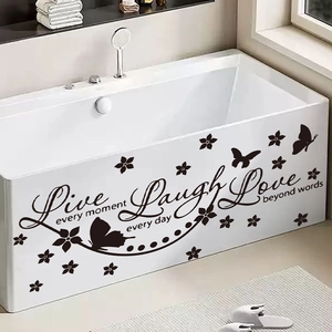 Live Laugh Love wall decal with butterfly accents on a white bathtub in a bright bathroom