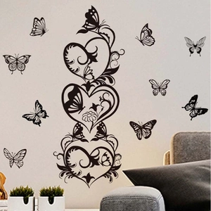 Elegant black butterfly and heart vine PVC wall stickers above a sofa in a living room