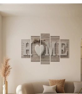 Detail of five-panel HOME canvas wall art hanging over a sofa in a warm living room