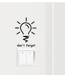 Detail view of the black 'don't forget' light bulb vinyl wall decal above a white switch