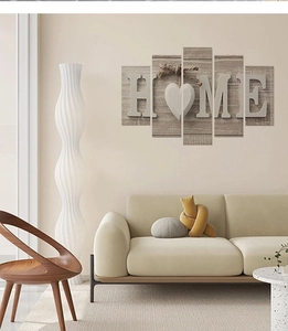 Detailed view of 5-piece 'HOME' canvas wall art with heart relief in a modern living room