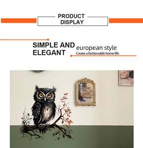 Close-up of black owl wall sticker on a branch with red leaves in modern room decor