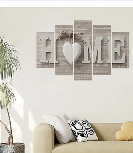 Detail of 5-piece canvas wall art featuring HOME letters and heart on wood background