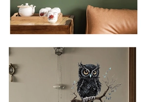 Detail of owl wall sticker on a branch with blue leaves in a cozy living room decor