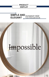 Modern round wall mirror with light wood frame and black Impossible lettering detail