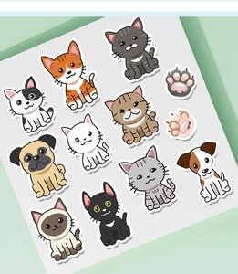 Close-up of cute cartoon cat and dog stickers with white die-cut edges on a green background