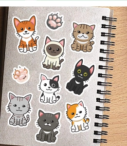 Detailed view of cute cartoon cat stickers and paw prints on a spiral notebook