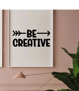 Close-up of BE CREATIVE wall sticker in black artistic font with arrow accents on pink wall