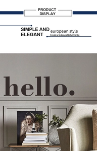 Close-up of black hello lettering wall decal on a modern living room grey wall