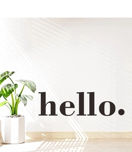 Detail view of black matte hello wall decal on a modern white living room wall decor