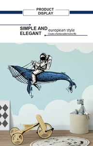 Astronaut riding whale wall sticker in a child's bedroom with stars and clouds