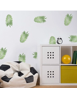 Tropical green leaves wall stickers decorating a cozy living room with a soccer sofa