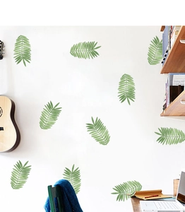 Detailed view of green tropical leaf wall stickers applied to a white office wall