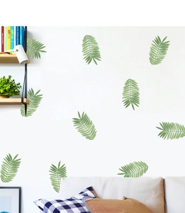 Detail showing watercolor green tropical leaf wall stickers in a cozy home office setting